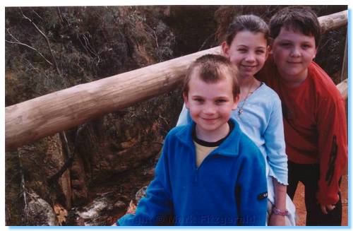 Kids on top of the heaviliy eroded Spring Creek, with the tunnel exist just visible